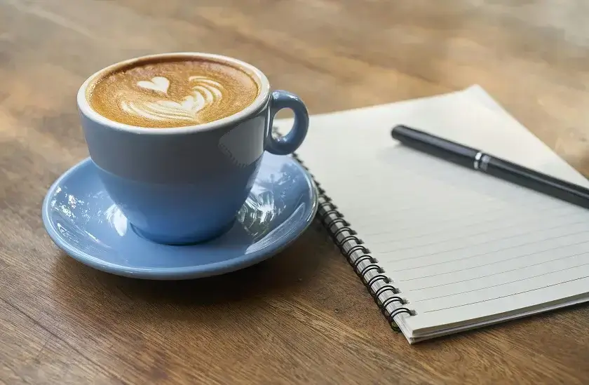 Kaffeetasse und Notizbuch – individuelle Finanzierungsvorschläge besprechen